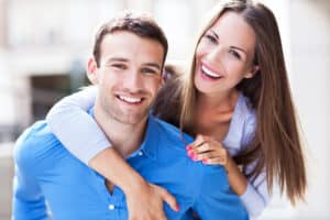Happy couple with different sized noses following rhinoplasty surgery to suit their genders